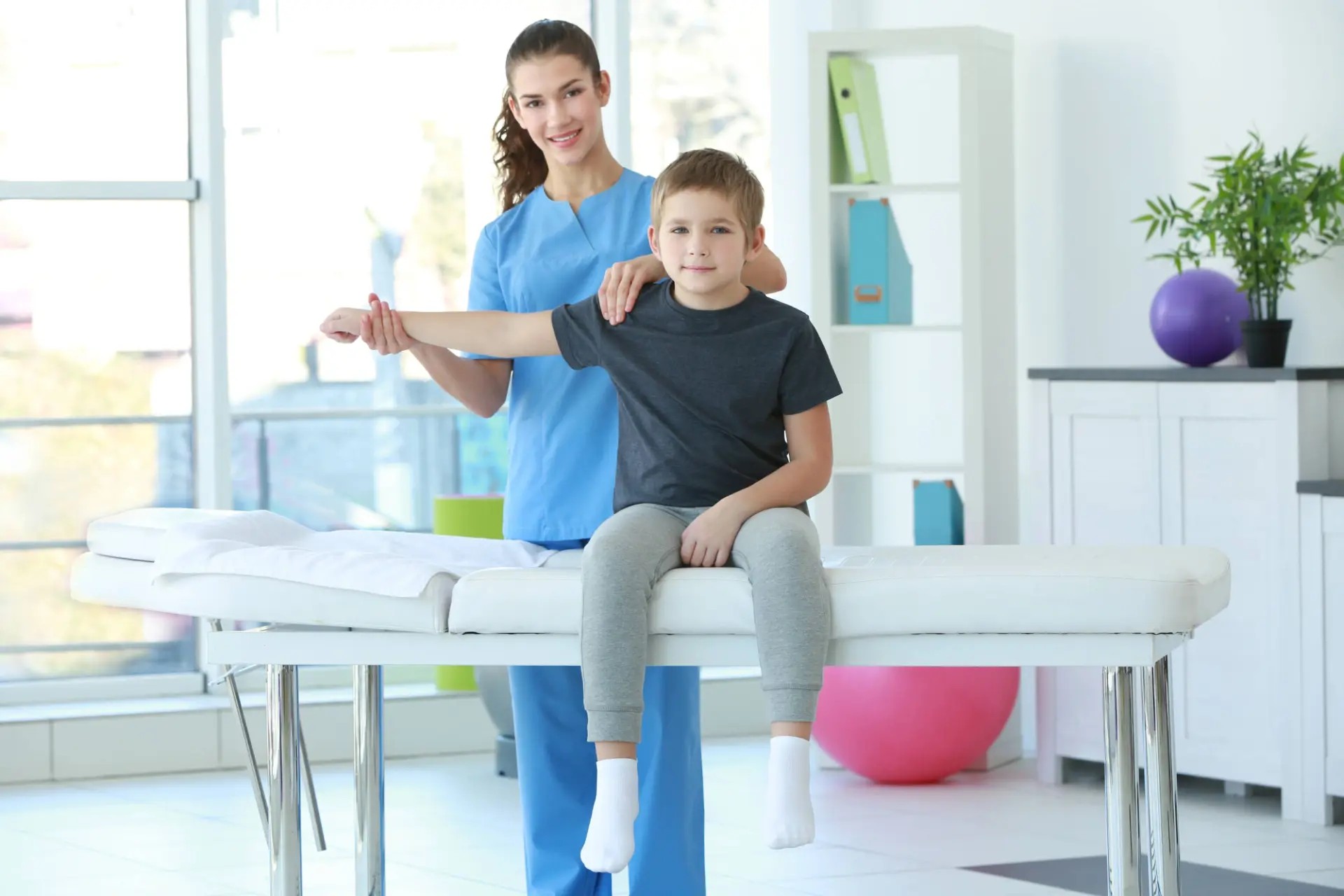 Provider guiding a young patient's arm during a pediatric chiropractic visit at Lovejoy Chiro & Med Spa in Allen, TX
